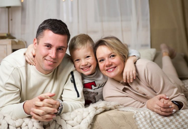 a man and woman with a couple of children on a bed