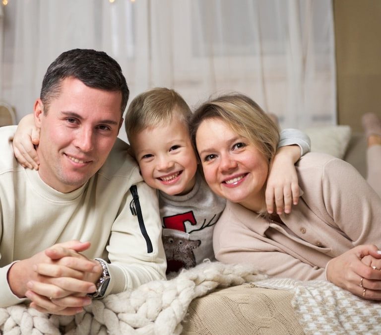 a man and woman with a couple of children on a bed